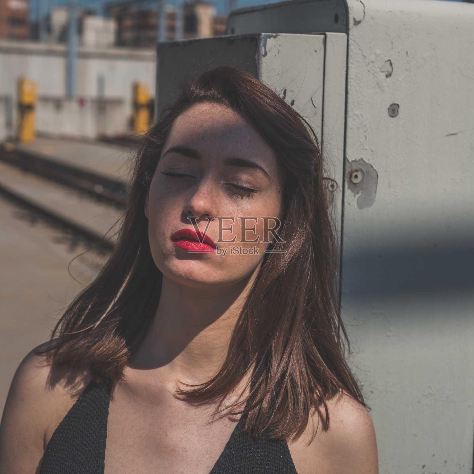 美丽的黑发在工业背景下摆姿势照片摄影图片