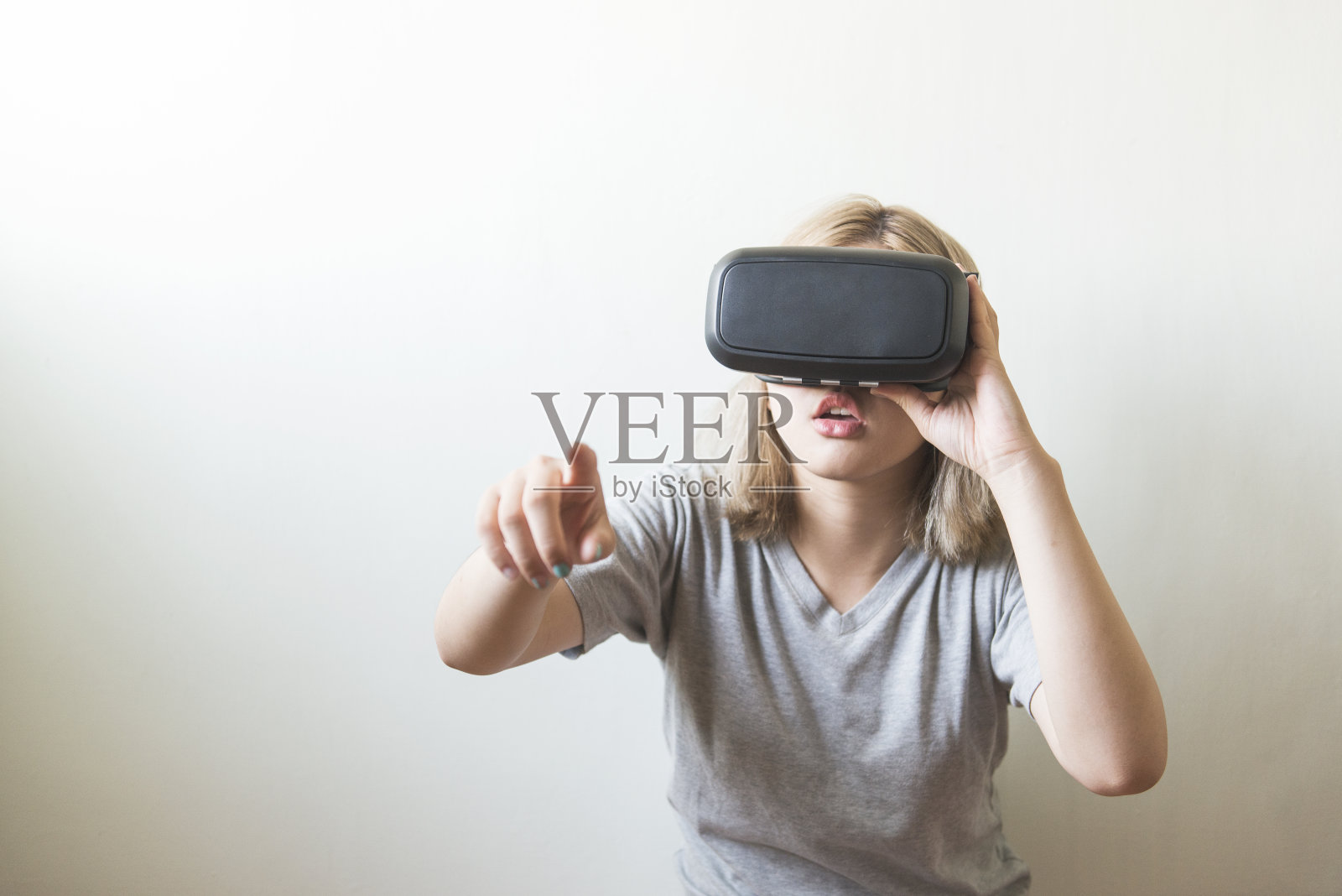 在白色背景上使用虚拟现实耳机的女人照片摄影图片