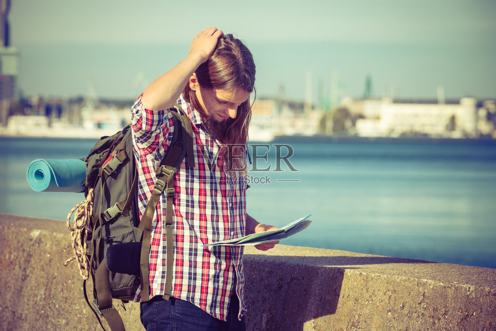 背着背包在海边徒步旅行的男子照片摄影图片
