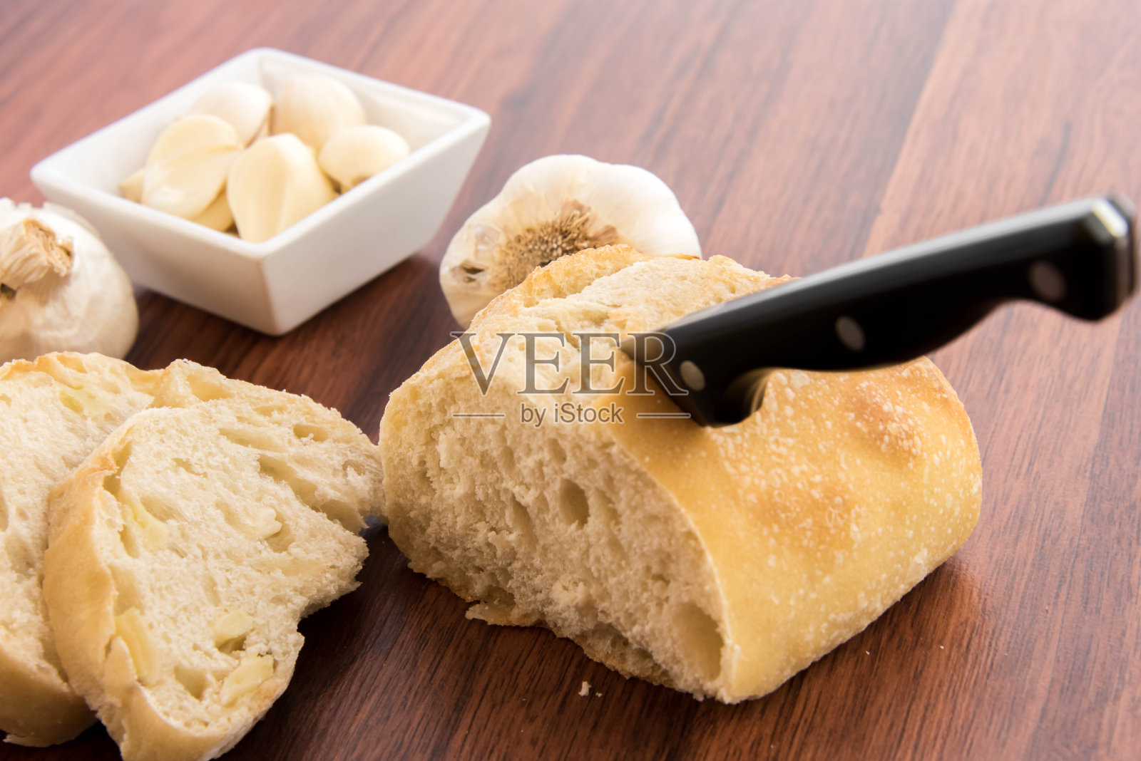 新鲜出炉的面包,加上整瓣大蒜照片摄影图片