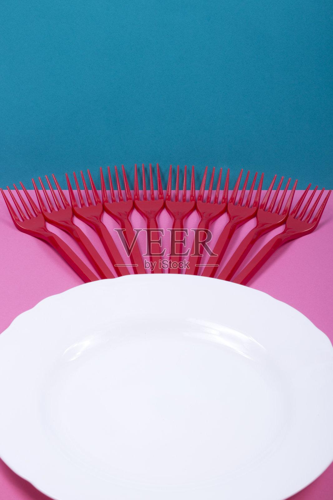 一个有彩色背景的塑料叉子和盘子的静物画照片摄影图片