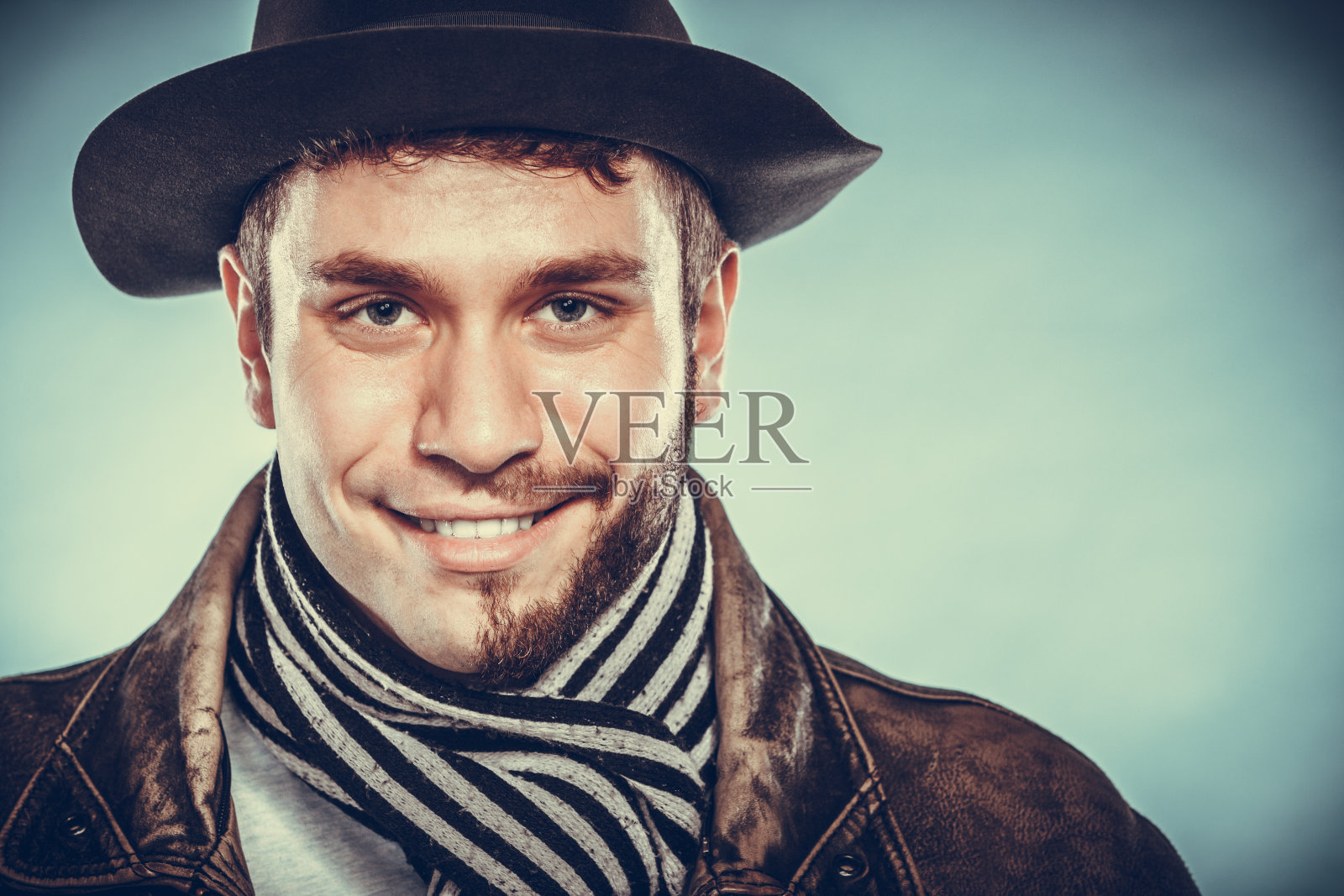 快乐的男人与半剃脸胡子头发在帽子。照片摄影图片