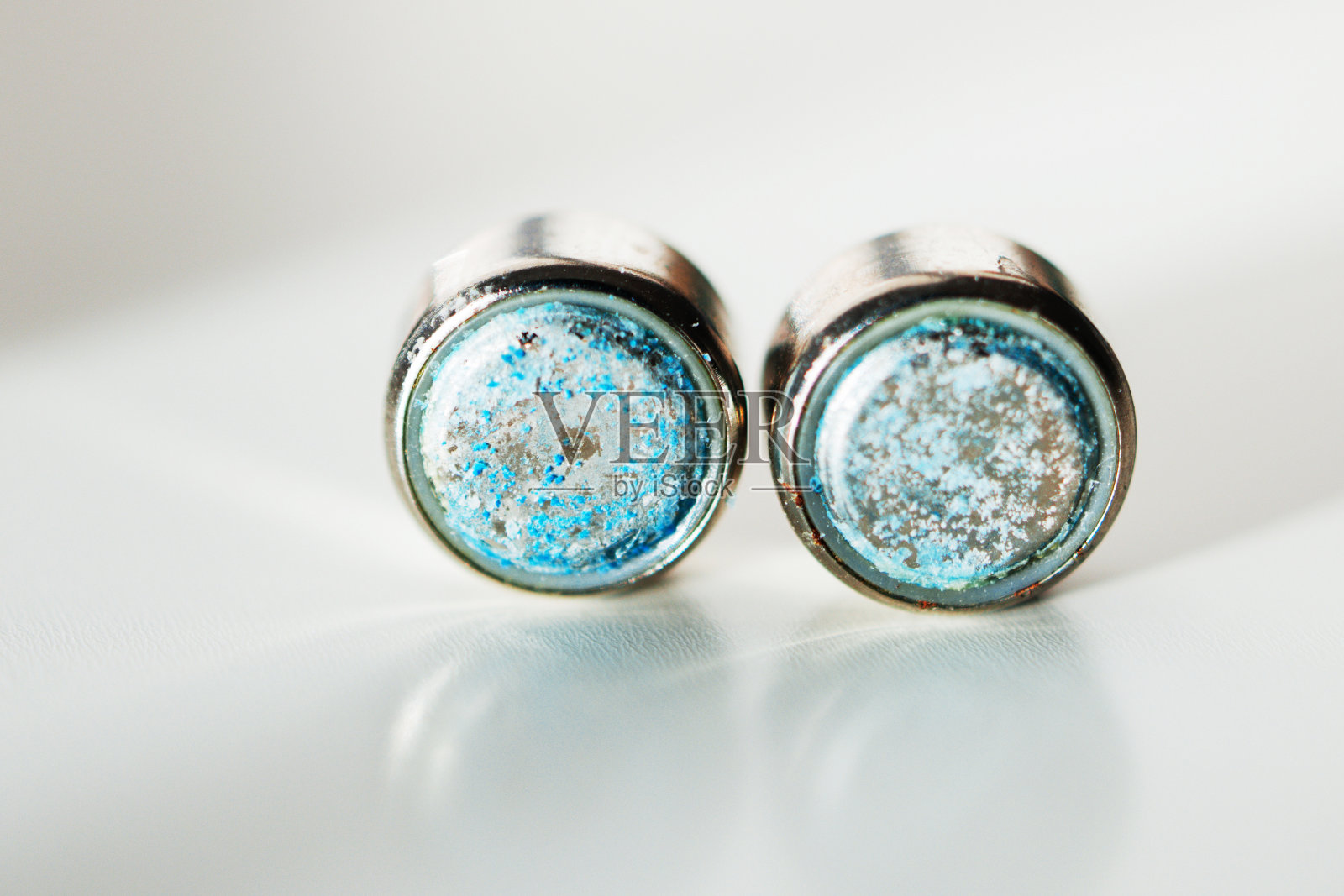 硬币电池在白色背景上腐蚀照片摄影图片