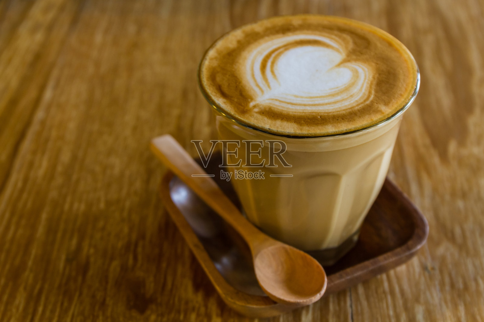 卡布奇诺或拿铁咖啡放在木桌上。照片摄影图片