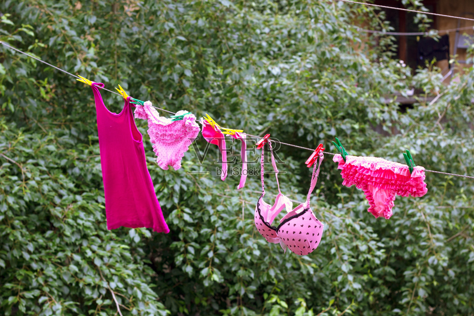 女人的粉色内衣会干的。照片摄影图片