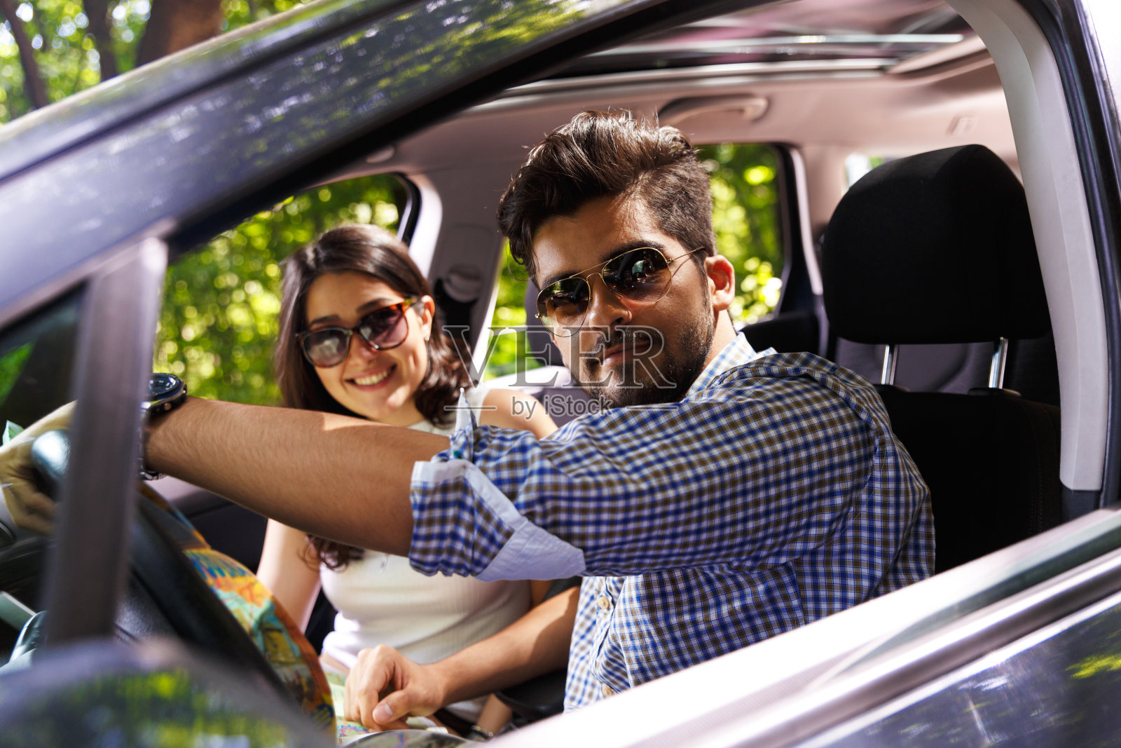 一对幸福的年轻夫妇,车里有地图。照片摄影图片