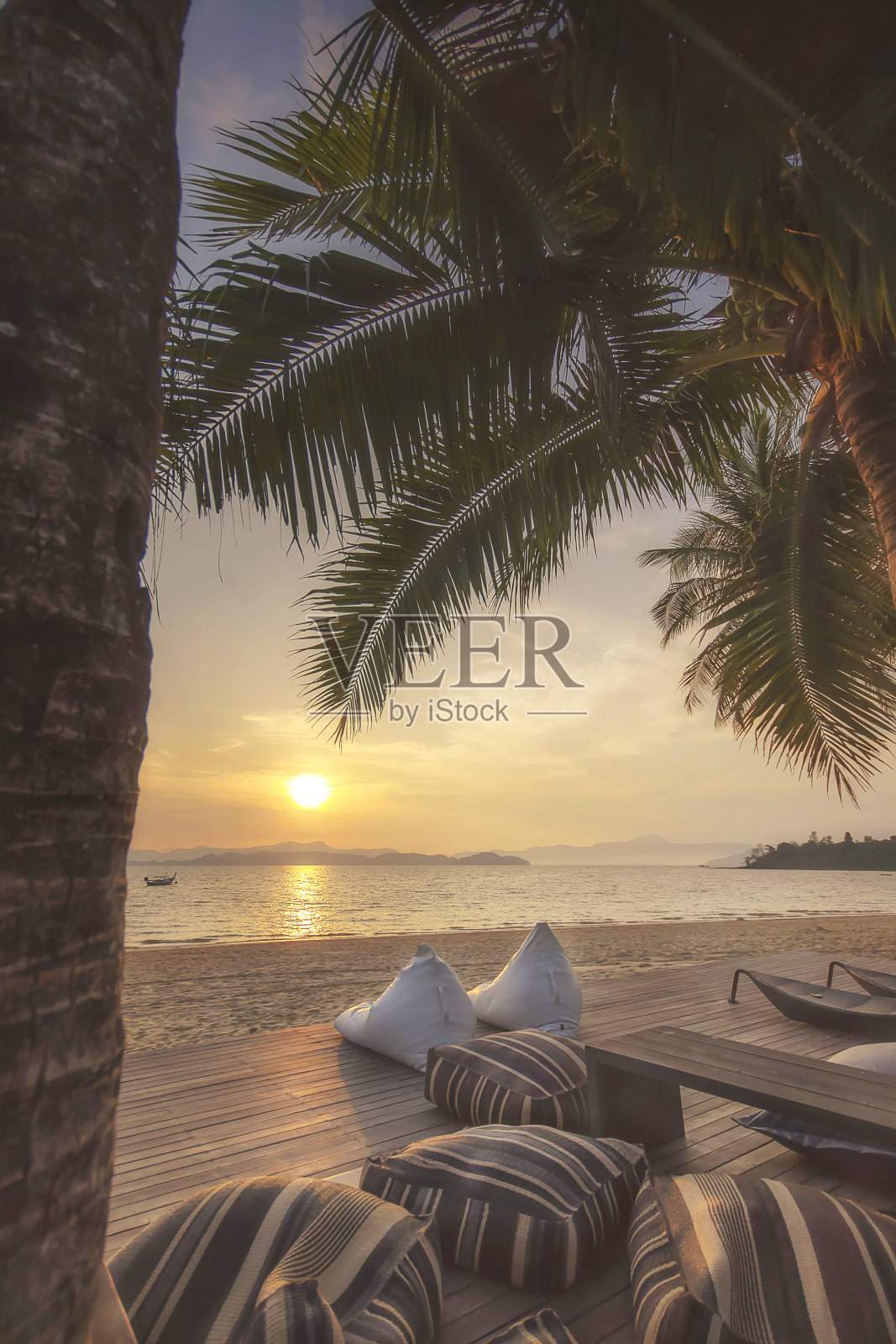 日出与靠垫和椰子树在海滩的背景照片摄影图片