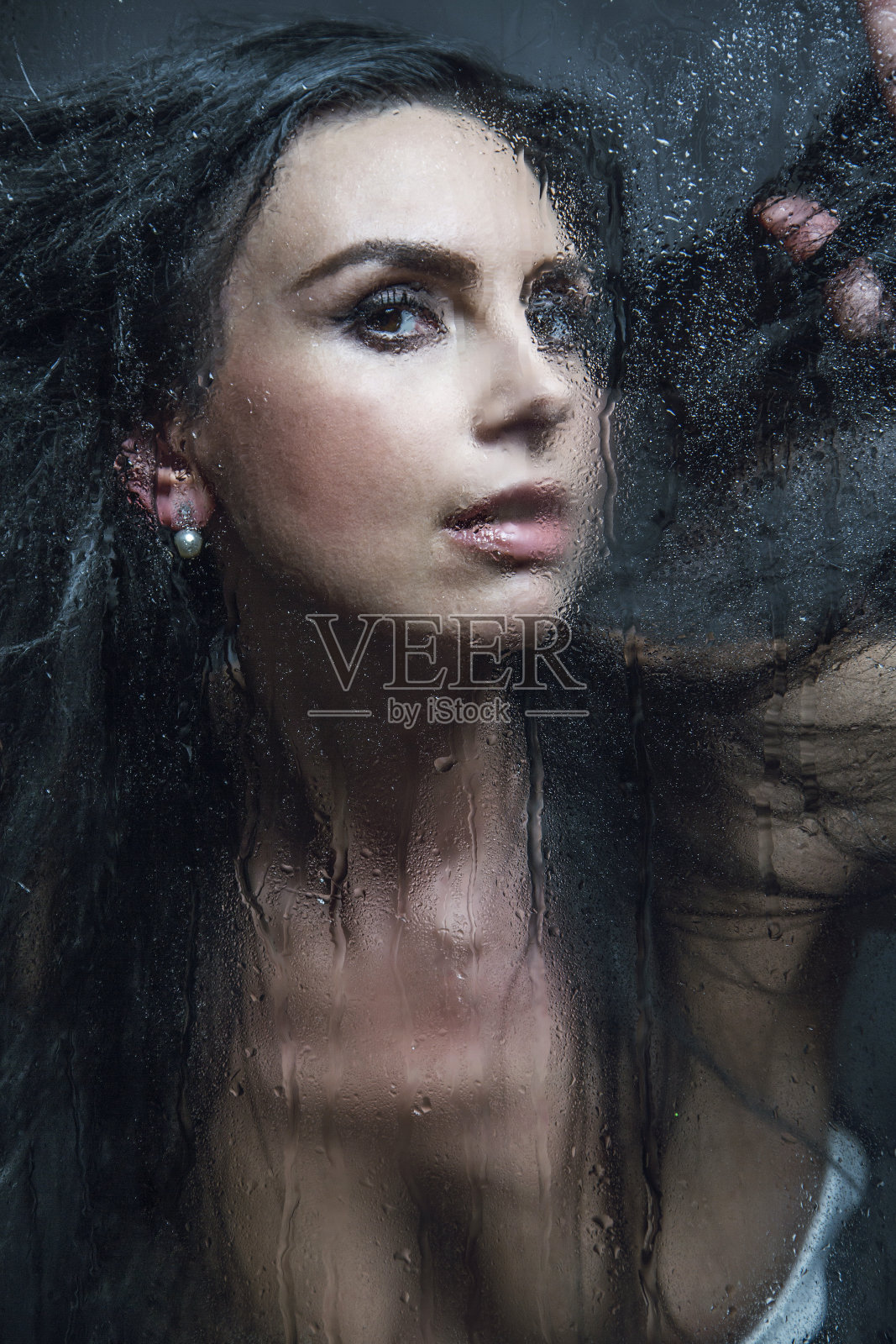 雨中窗边的年轻女性的手照片摄影图片