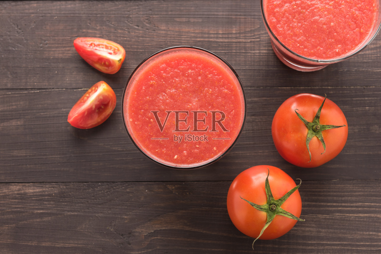 健康的蔬菜。木桌上放着一杯红色的番茄汁照片摄影图片