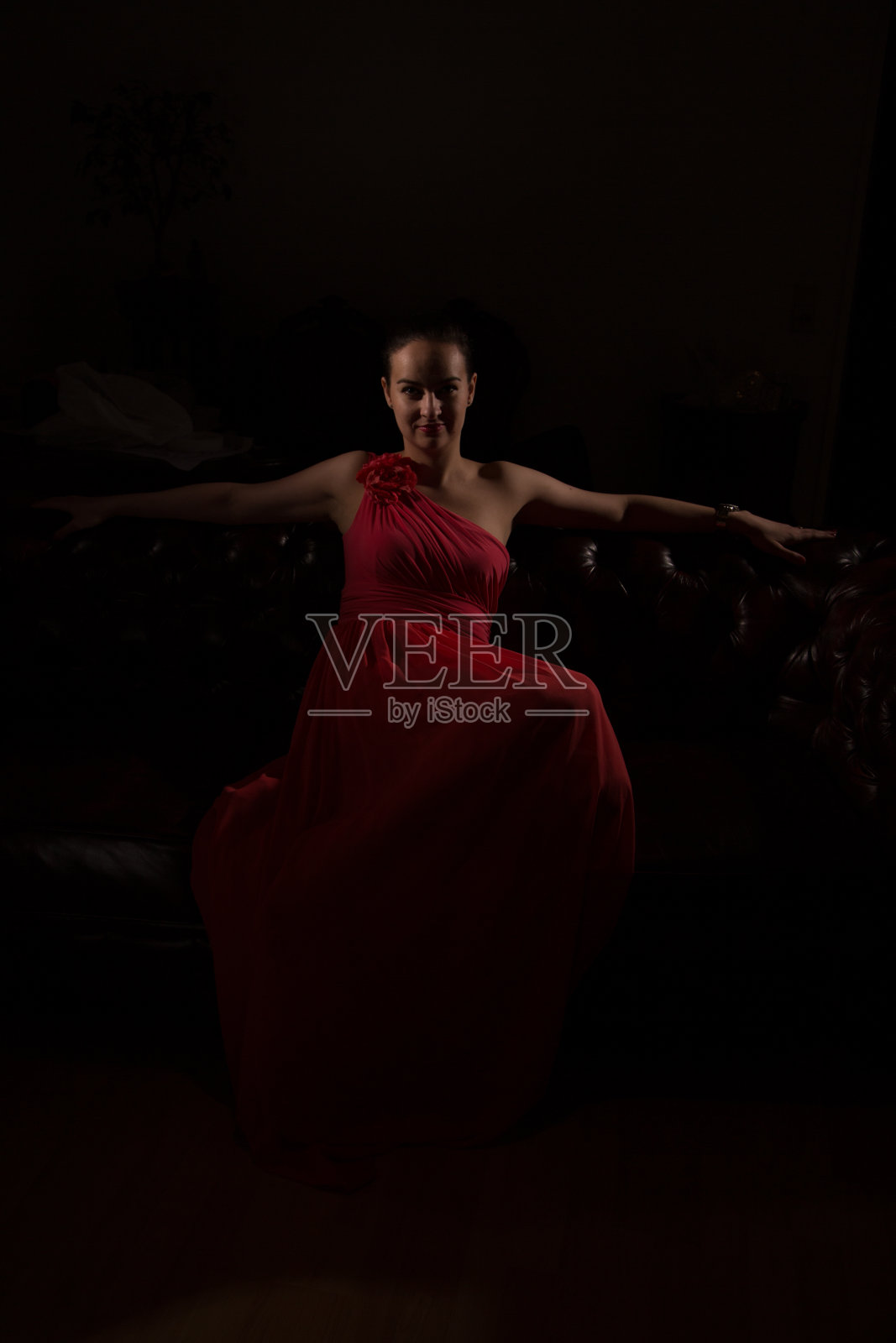 黑屋子里穿红衣服的女士照片摄影图片
