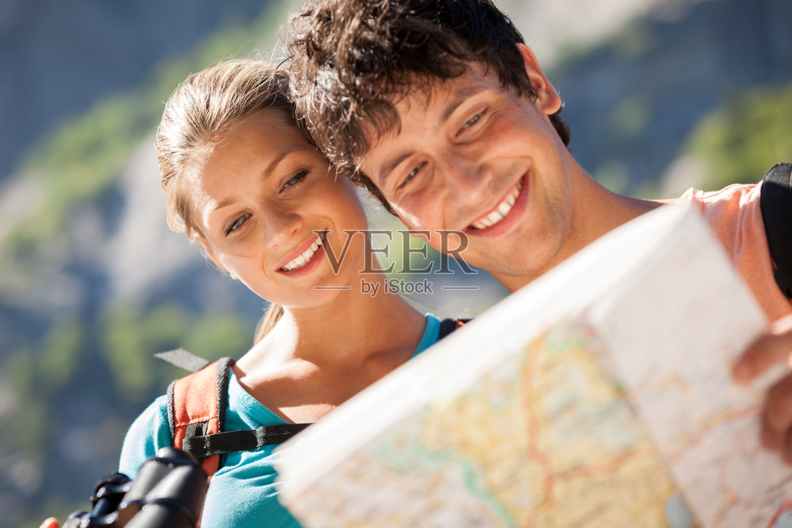 一对夫妇在山上看地图的特写照片摄影图片