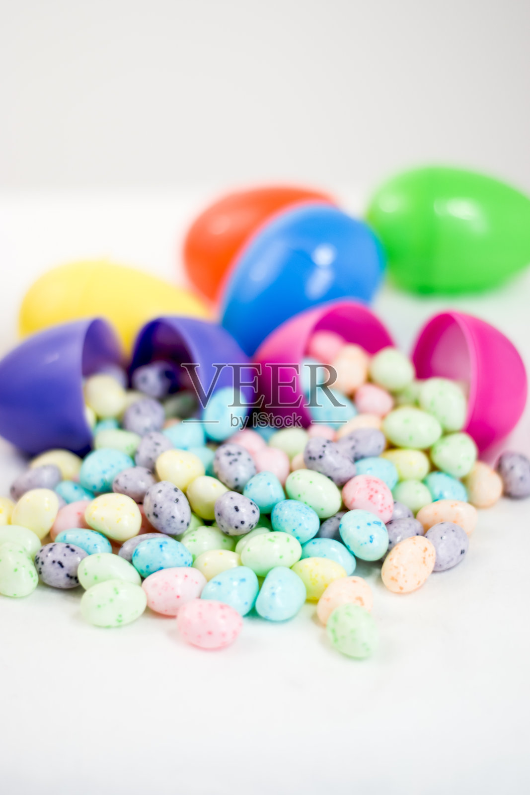 打开里面有糖果和软糖的复活节彩蛋照片摄影图片