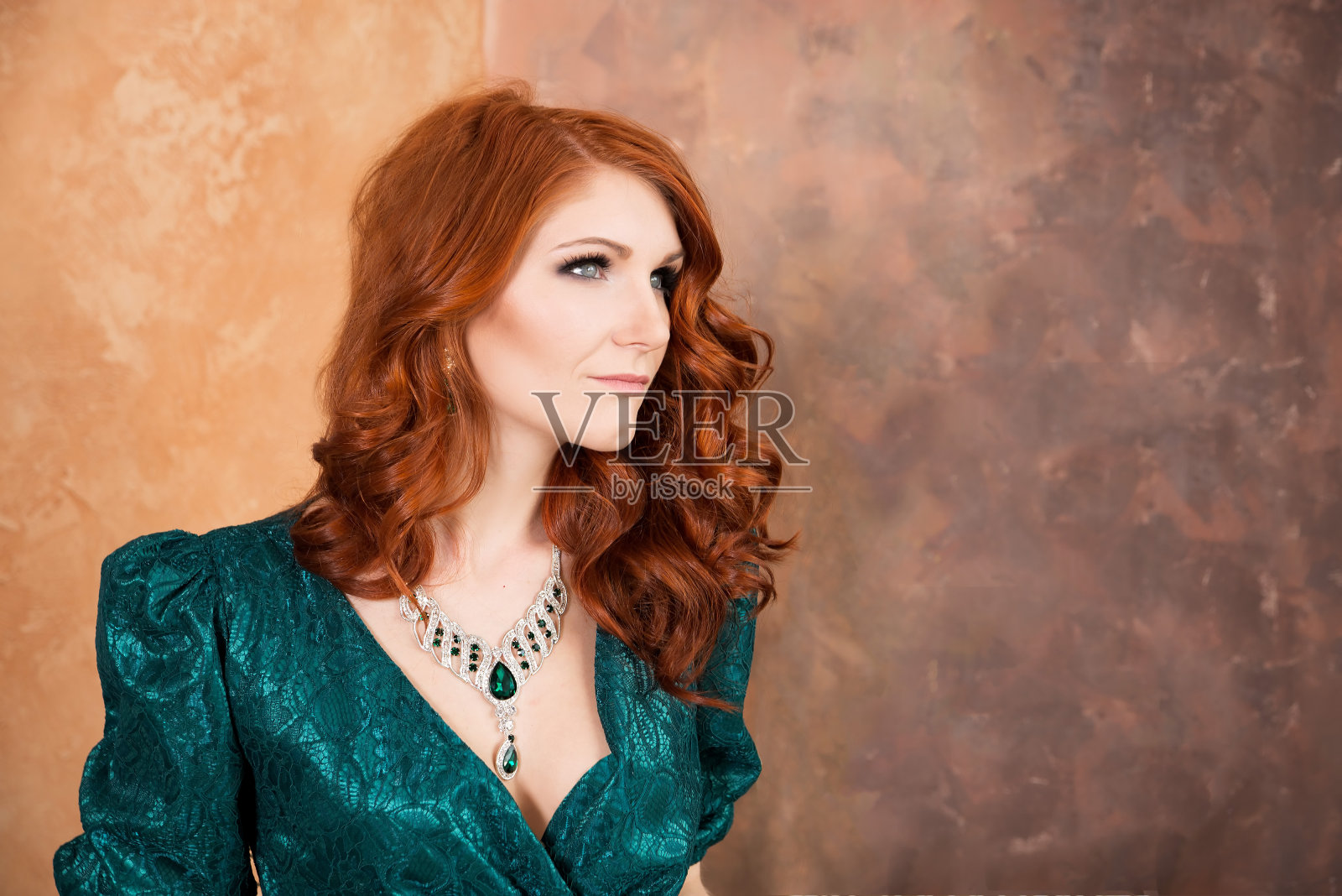 优雅的女性在复古风格的坐姿。绿色的裙子照片摄影图片