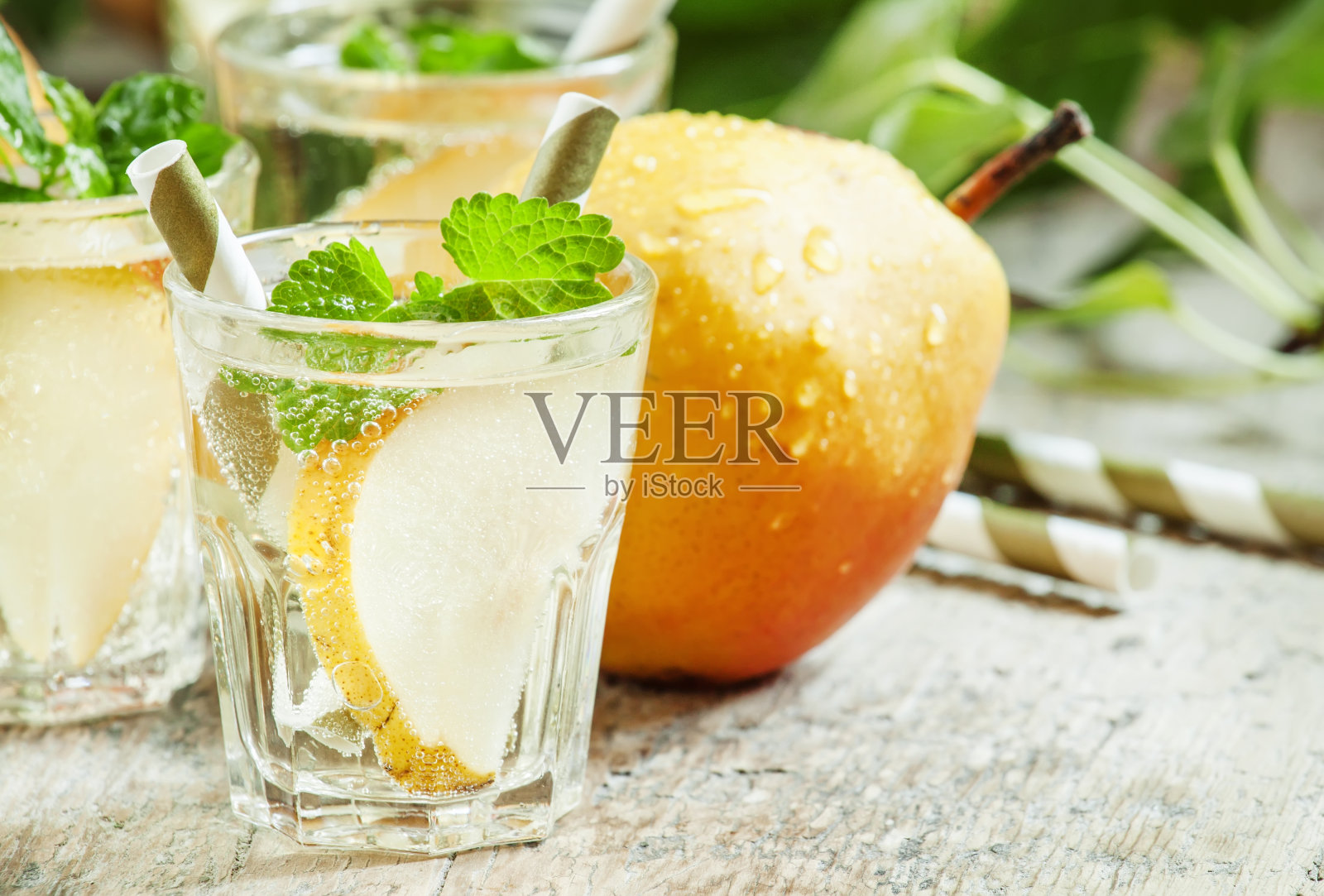 梨鸡尾酒配苏打水,水果片和薄荷照片摄影图片