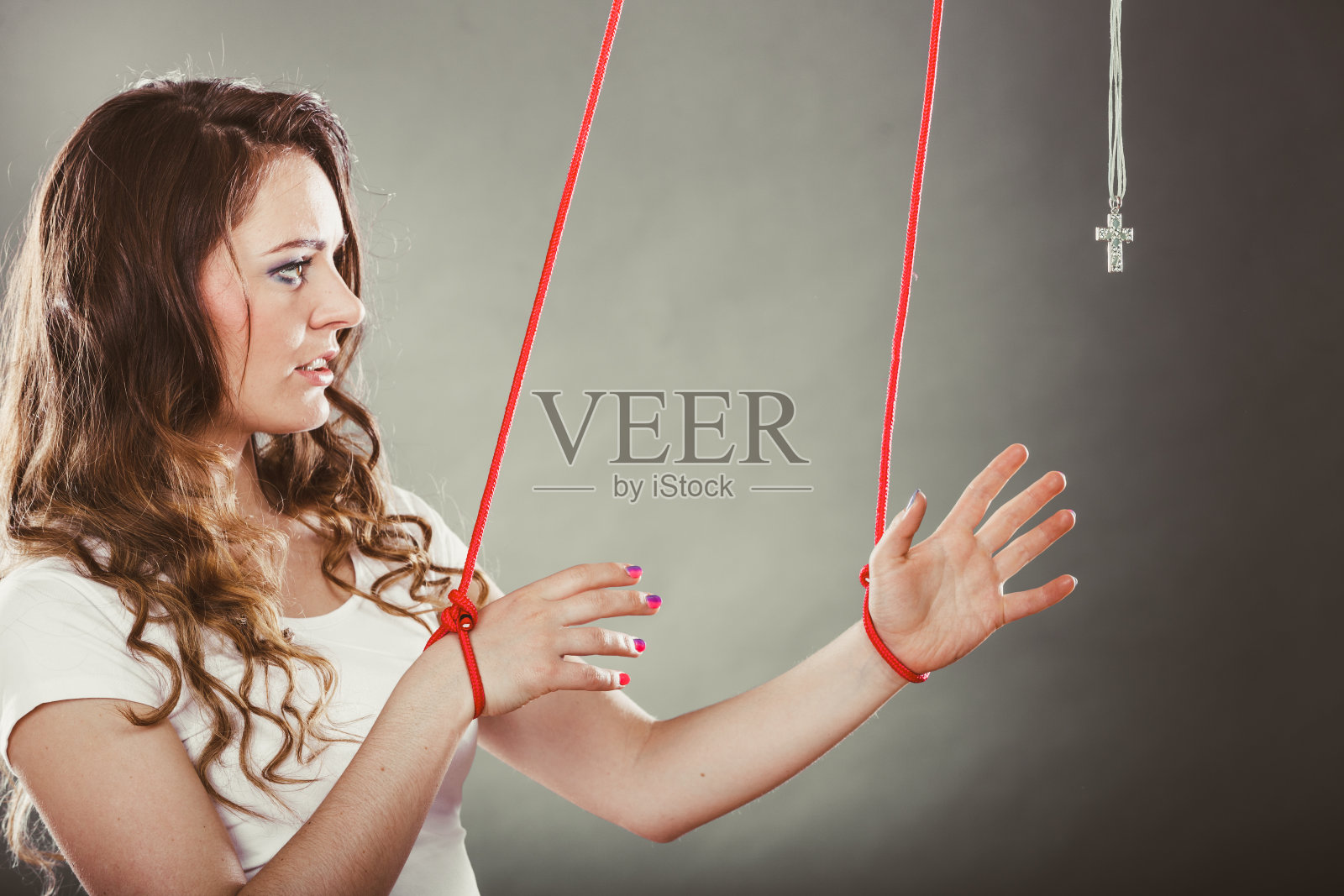 被绑的女人被迫祈祷。假的信仰。宗教。照片摄影图片