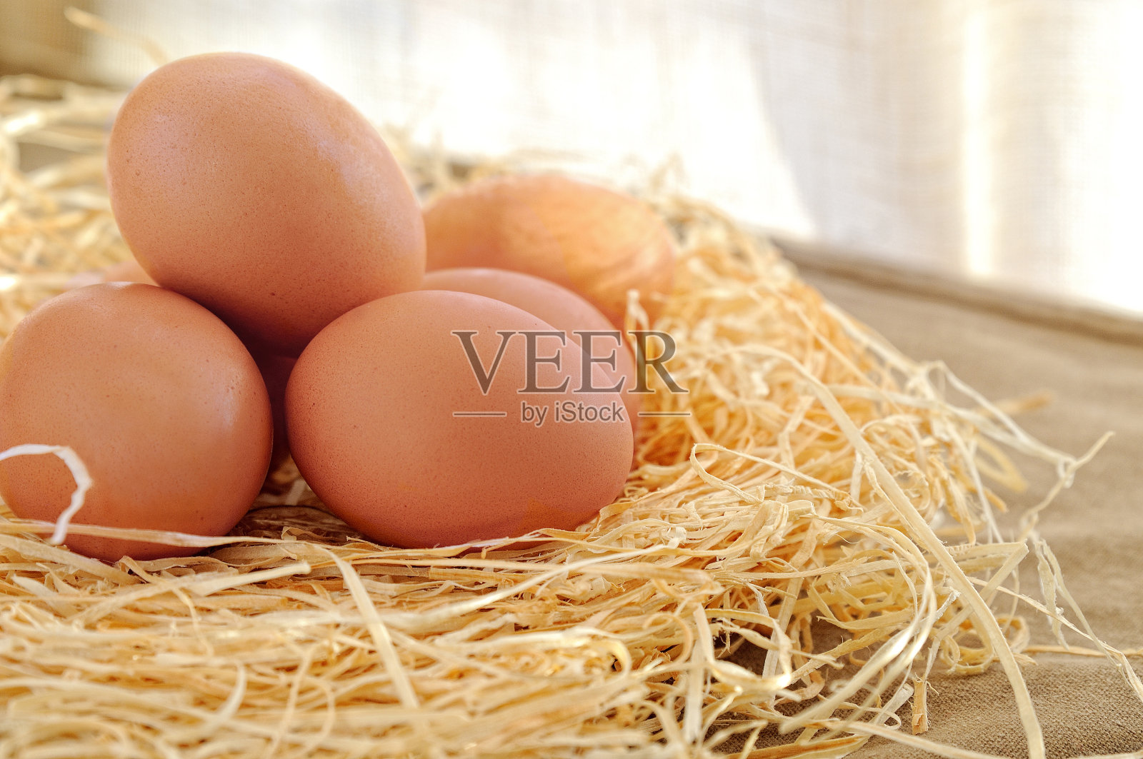 新鲜的鸡蛋放在稻草上放在桌子上照片摄影图片