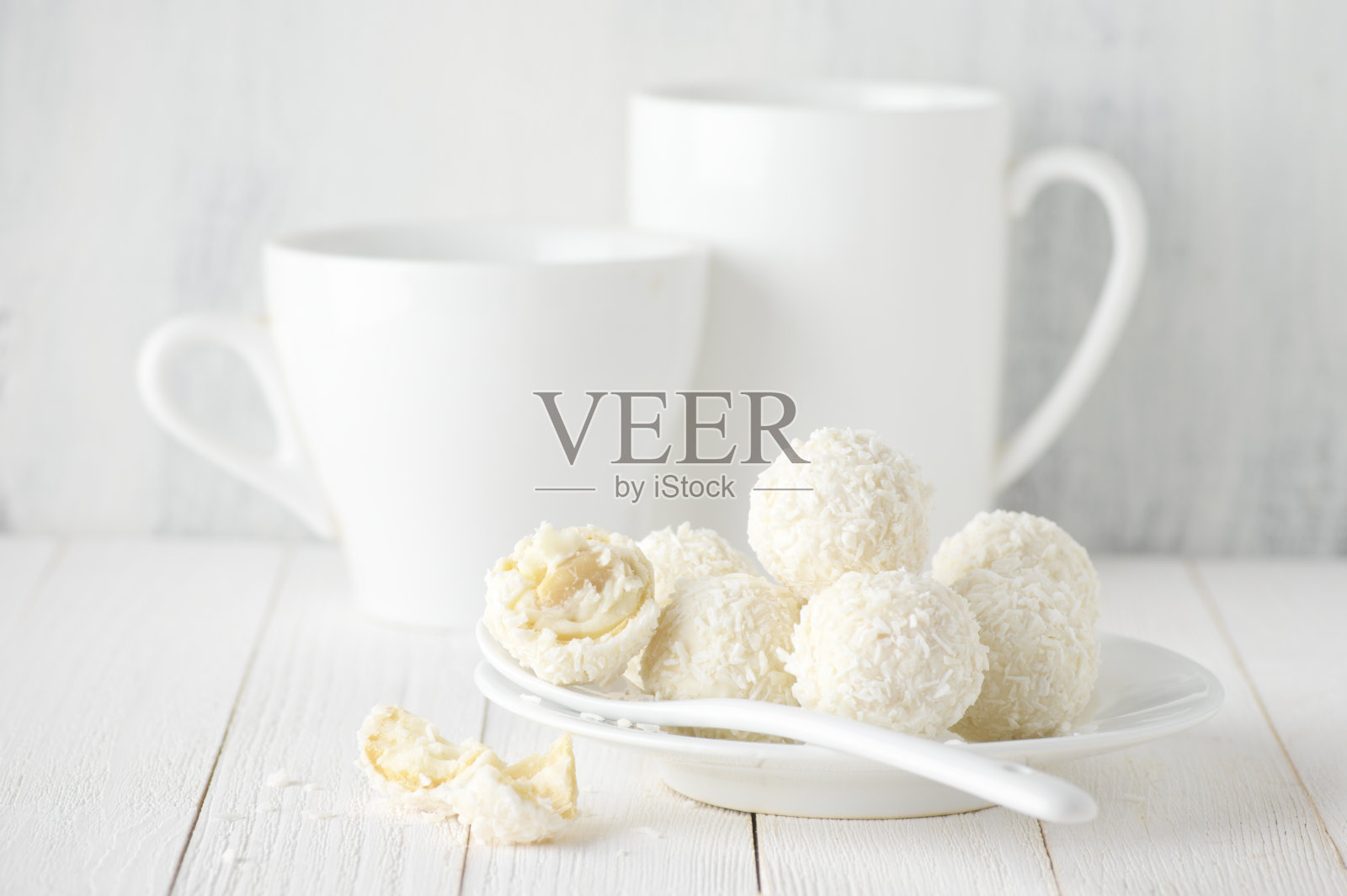 椰子糖堆在白色的盘子和杯子里照片摄影图片