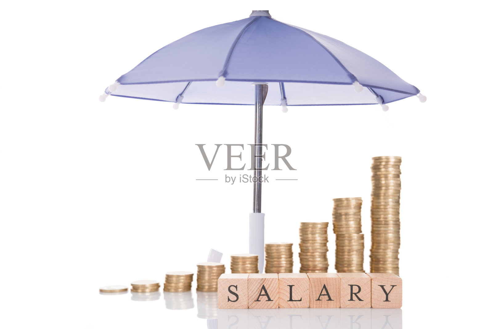 在伞下堆叠硬币和薪水块照片摄影图片