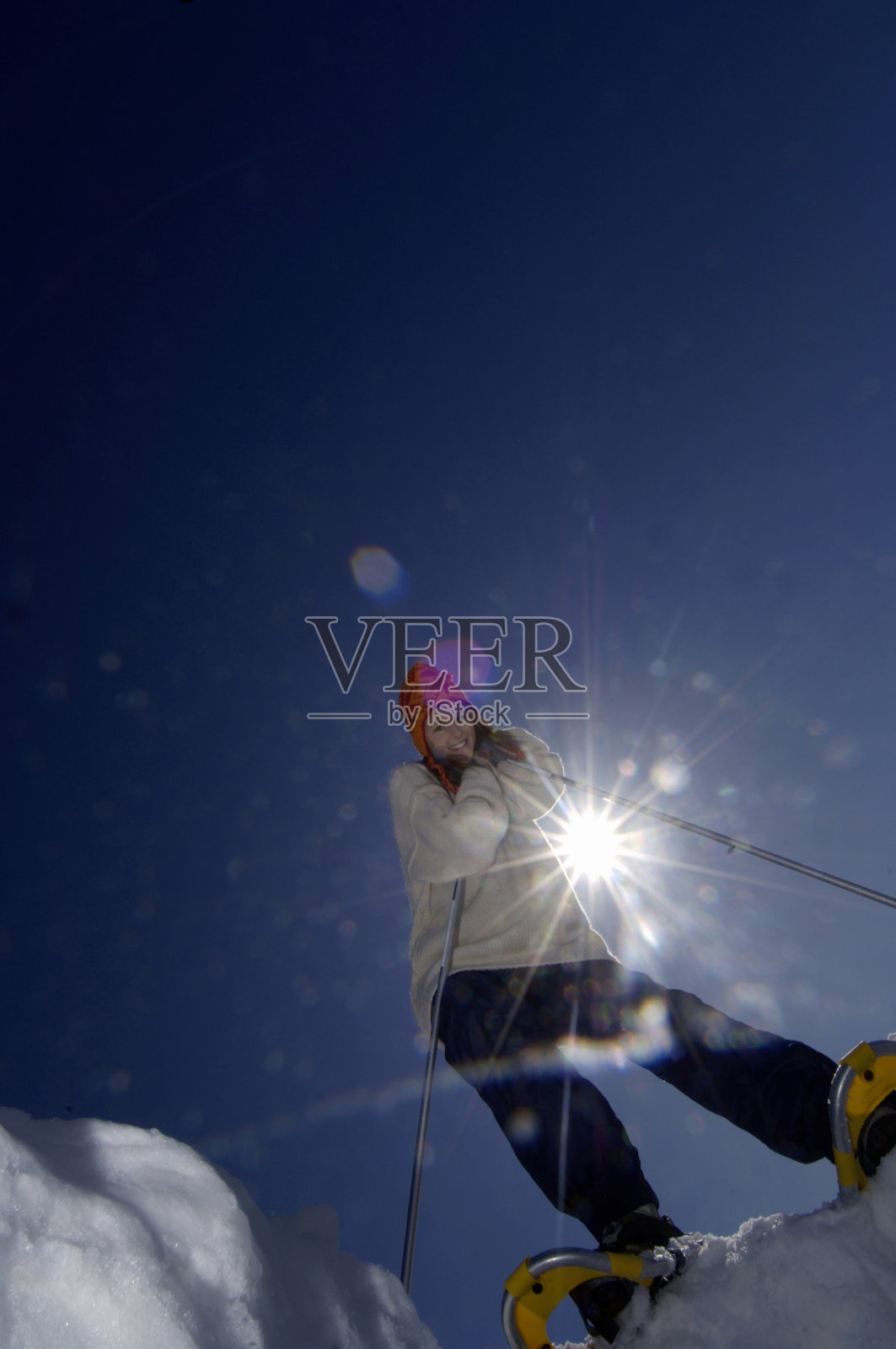 年轻女子靠在滑雪杆上照片摄影图片