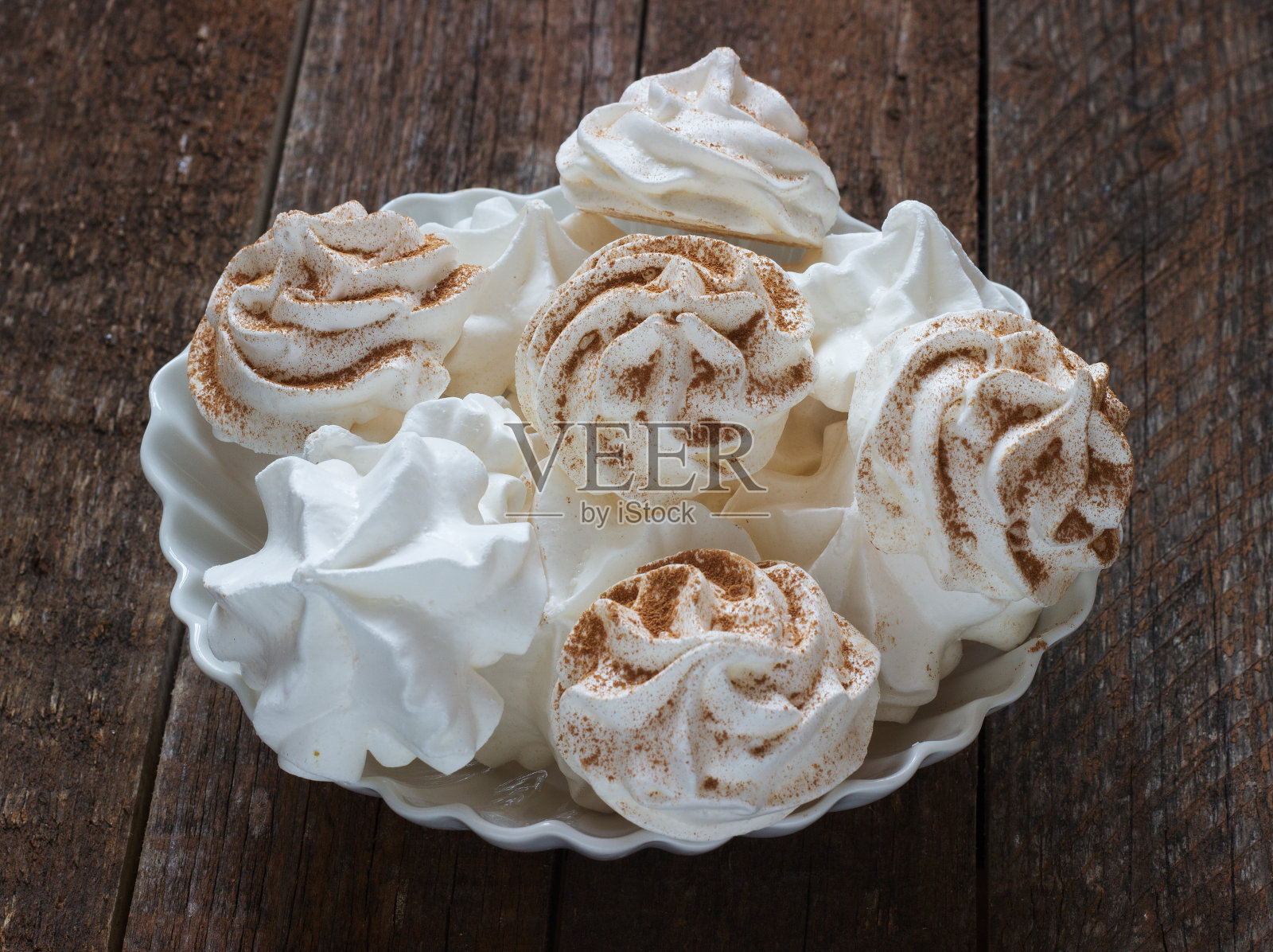 深色木质背景上的白色蛋白酥皮照片摄影图片