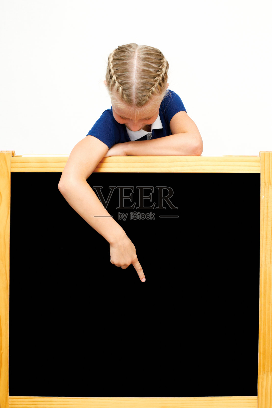 可爱的女学生指着黑板。照片摄影图片