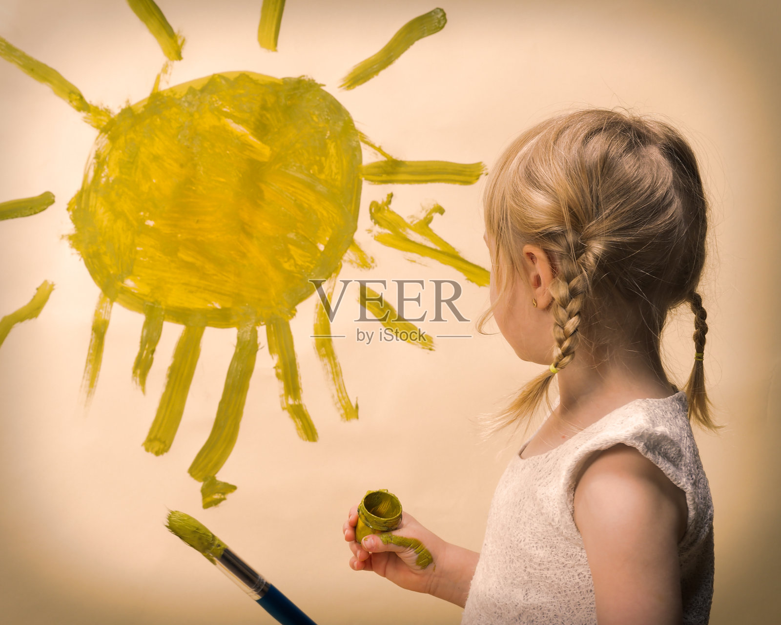 孩子把太阳画在墙上照片摄影图片