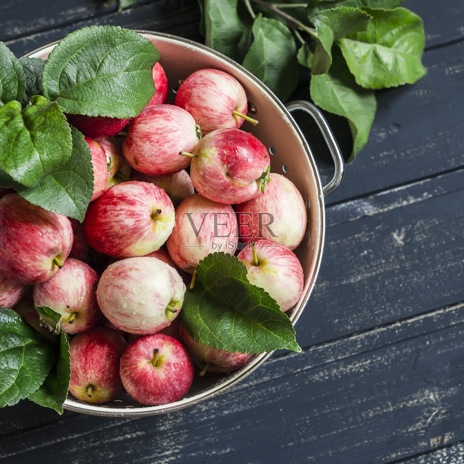 新鲜成熟的花园苹果在一个古老的漏勺照片摄影图片