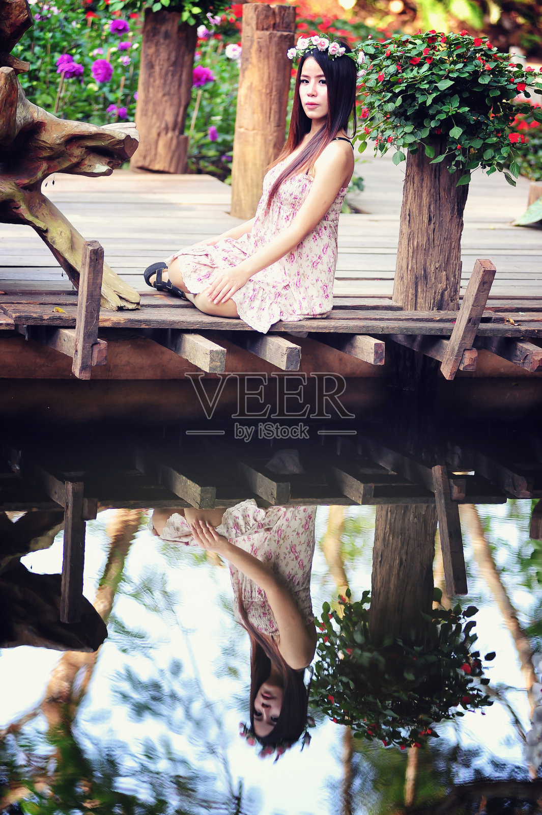 亚洲年轻女子坐在五彩缤纷的花园里照片摄影图片