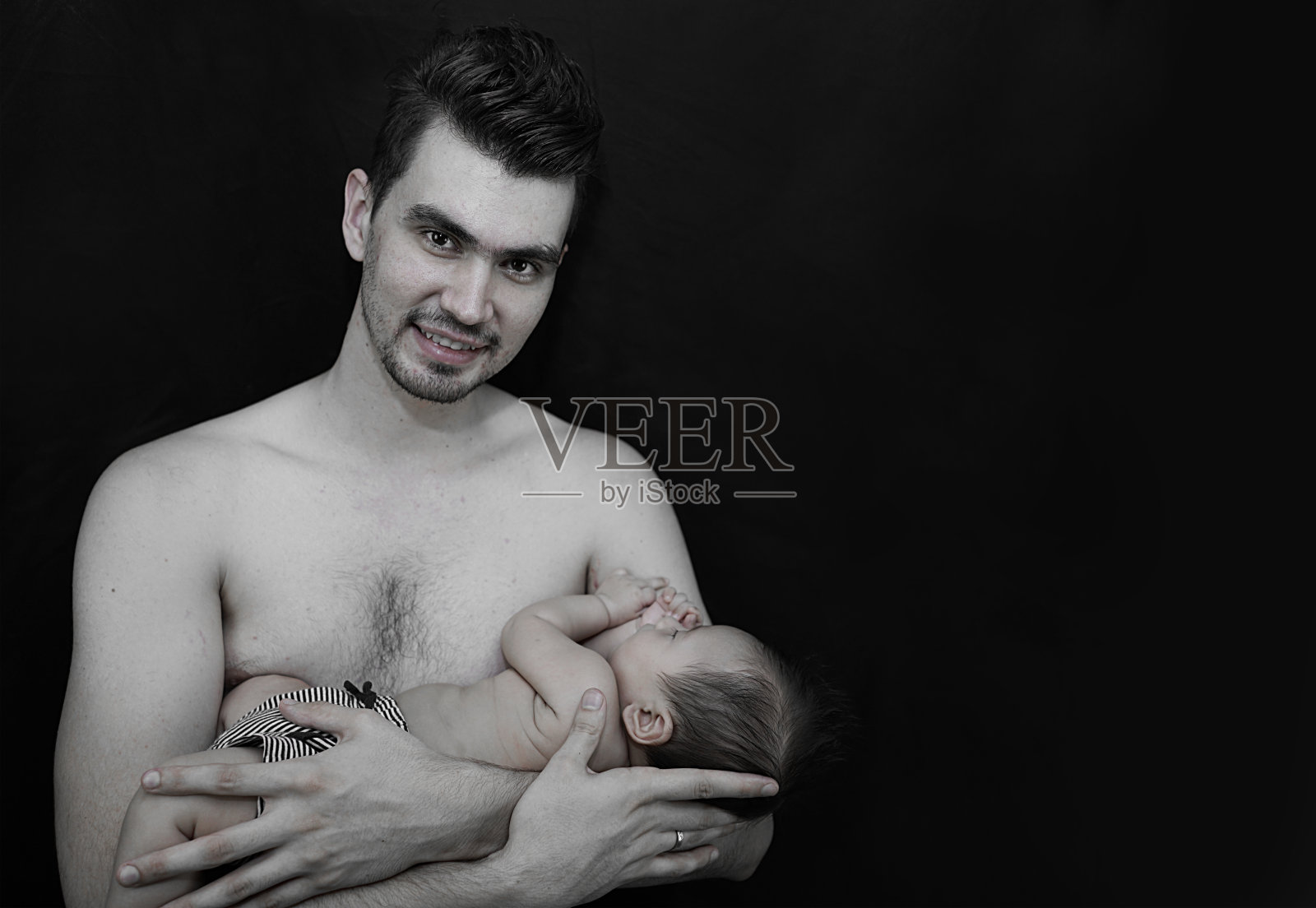 父亲抱着男婴黑色背景照片摄影图片