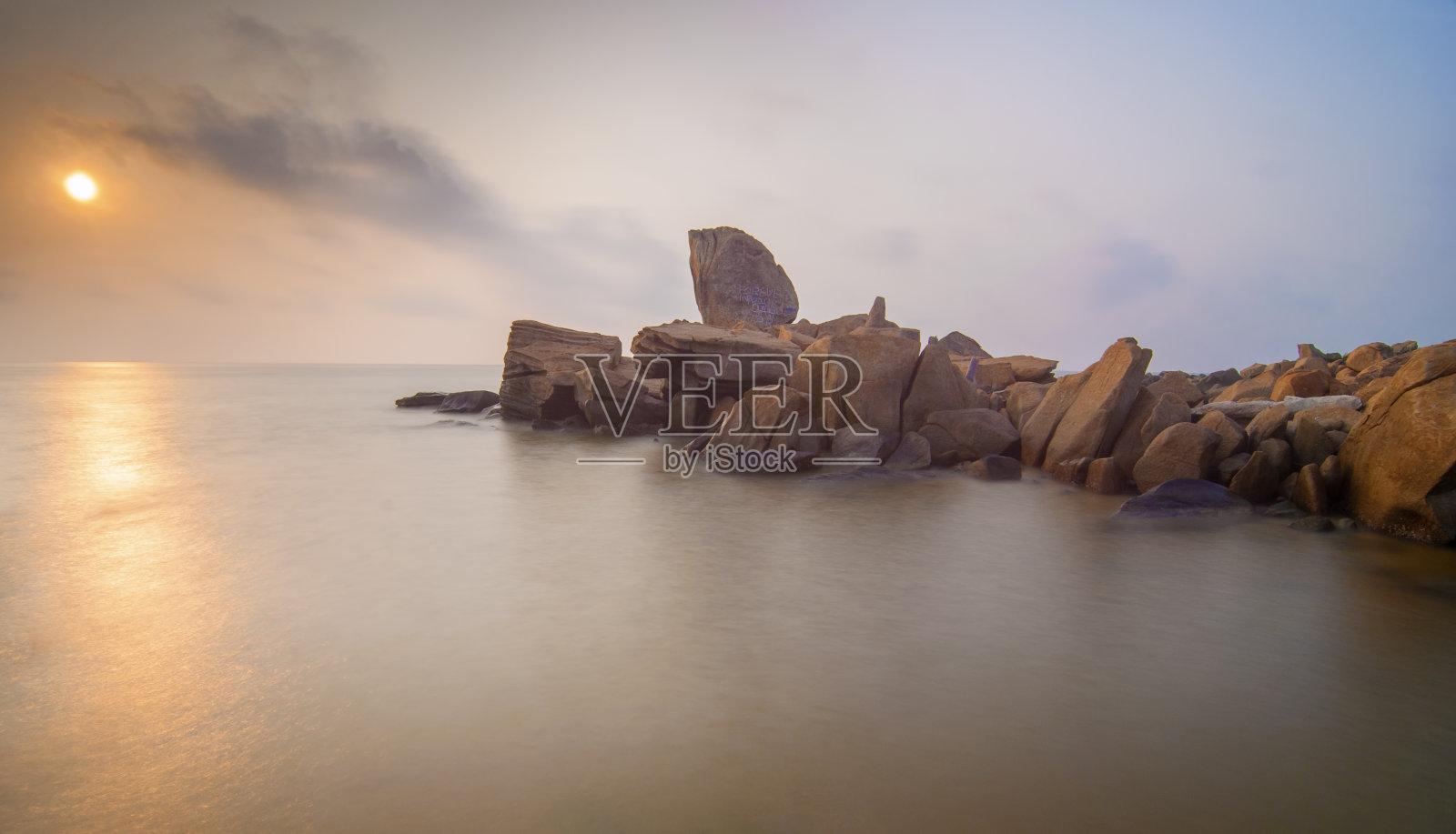 美丽的岩石景观日落在海上照片摄影图片