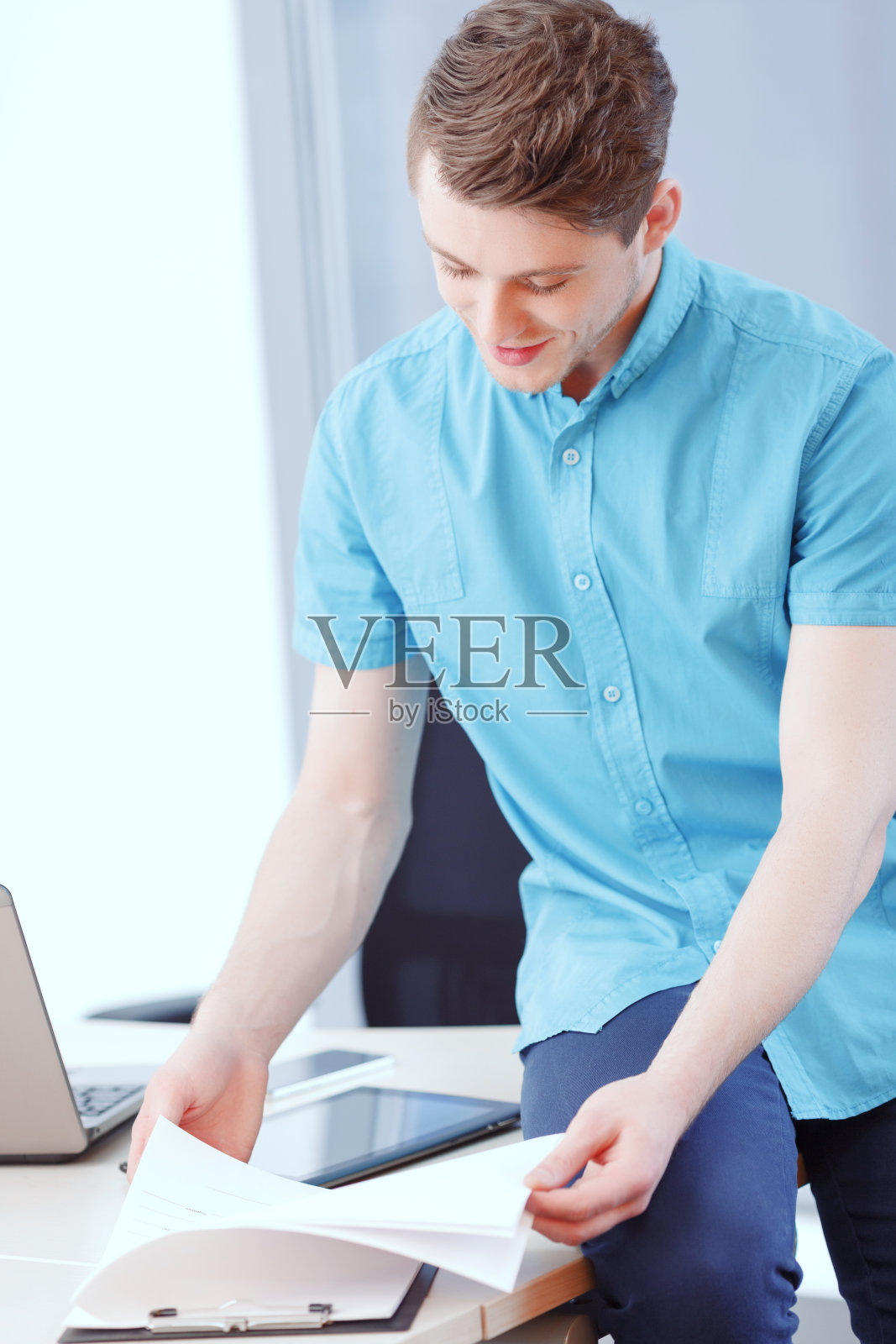 一个坐在桌子上看文件的人照片摄影图片