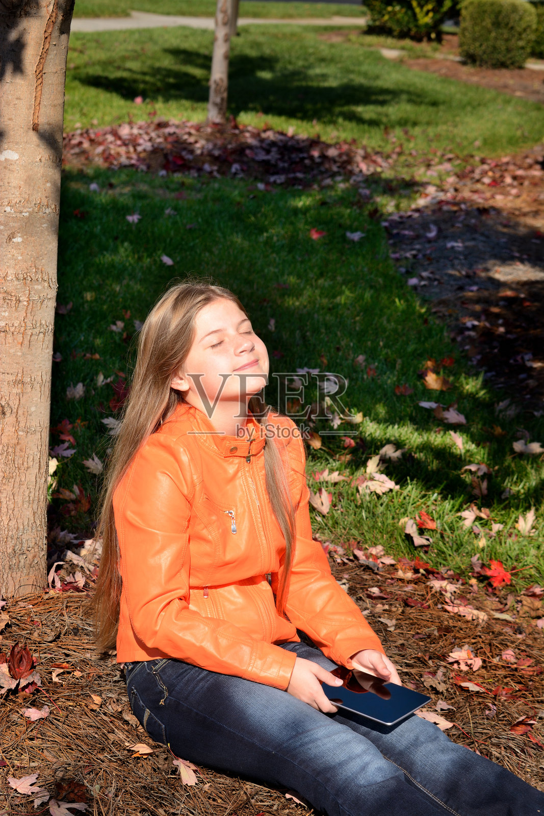 孩子带着平板电脑在公园里放松,照片摄影图片