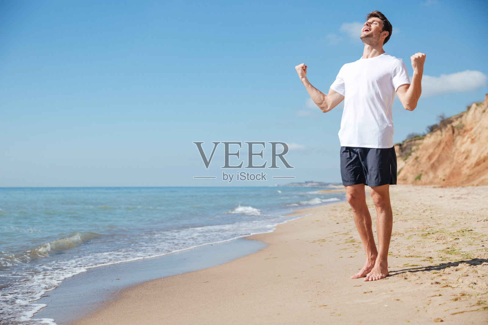 快乐兴奋的人在海滩上举起双手庆祝成功照片摄影图片