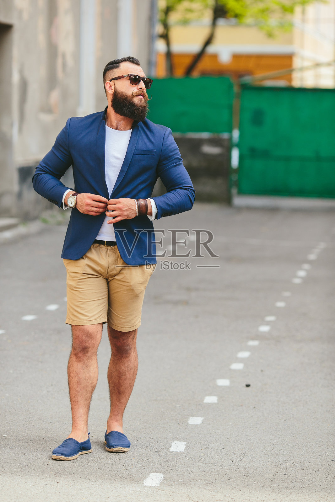 有型胡须的男人穿过城市照片摄影图片