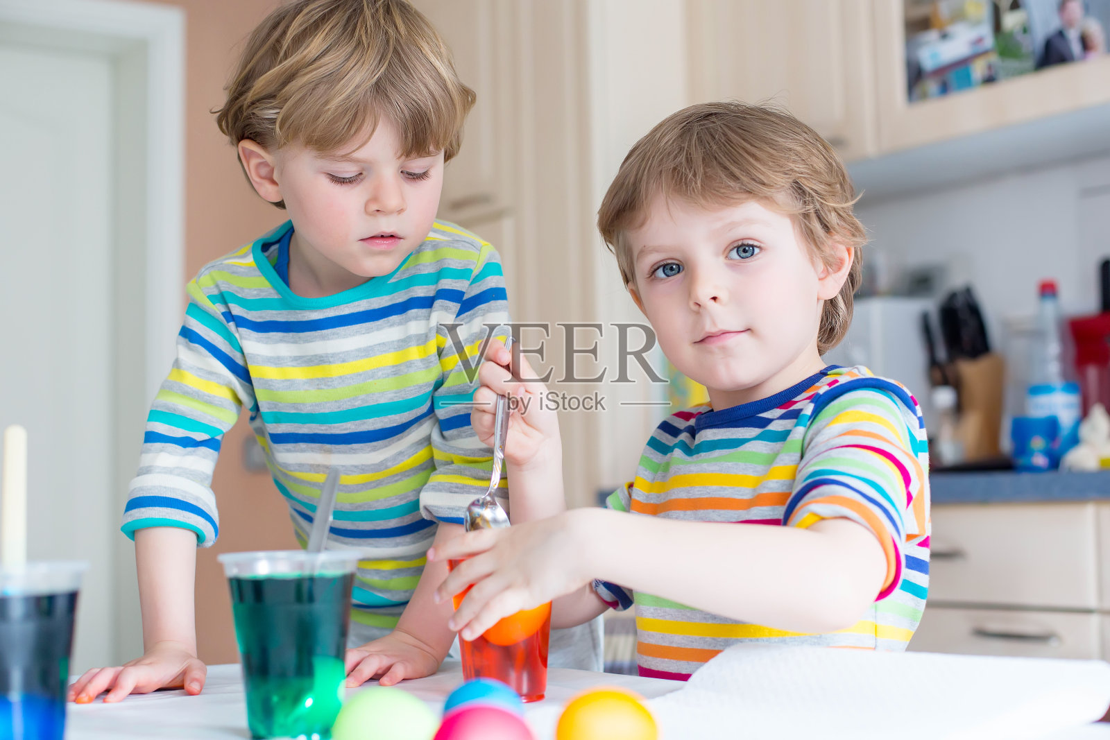 两个金发小男孩在为复活节画彩蛋照片摄影图片