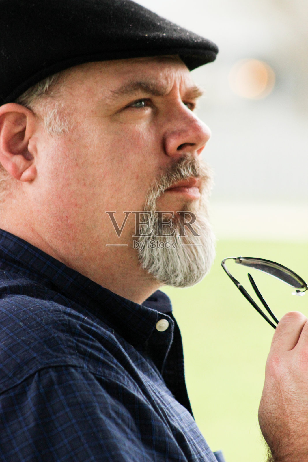 戴着帽子的男人手里拿着太阳镜照片摄影图片