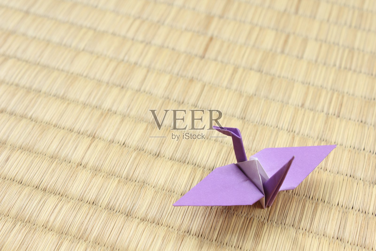 紫色纸鹤坐在日本传统的榻榻米地板垫子上照片摄影图片