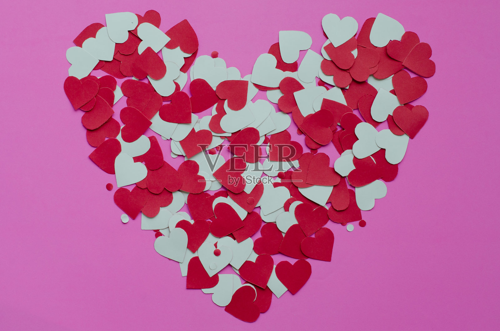 粉色背景上的心形纸。照片摄影图片