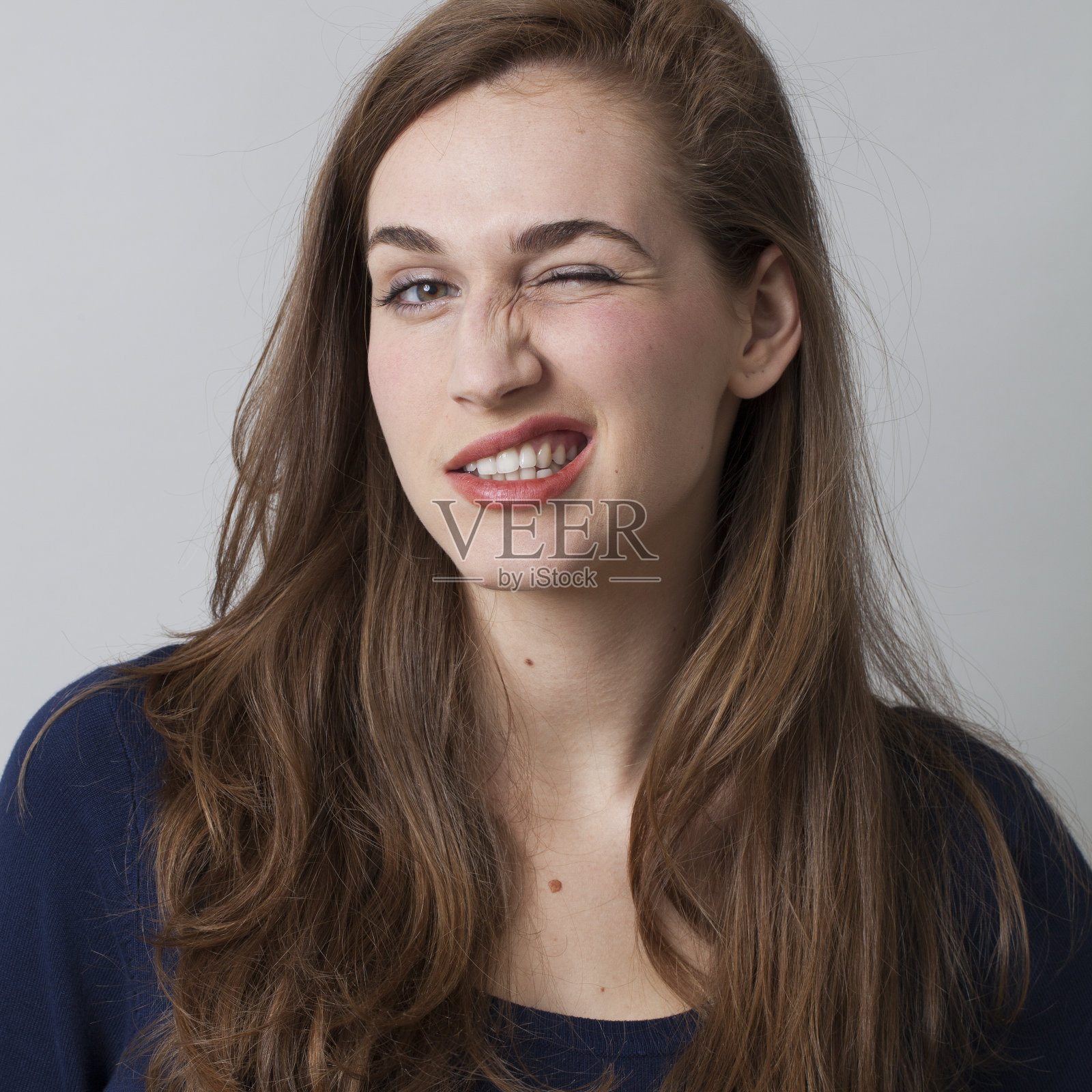 自信的20多岁棕发女子眨眼庆祝成功照片摄影图片