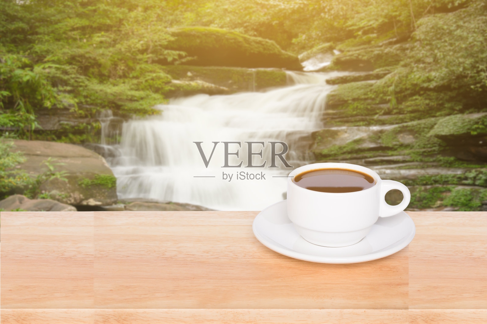 木桌子咖啡杯与模糊瀑布背景照片摄影图片