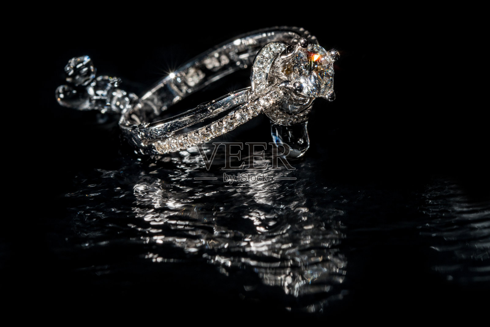 结婚戒指沉入水中,黑色背景照片摄影图片