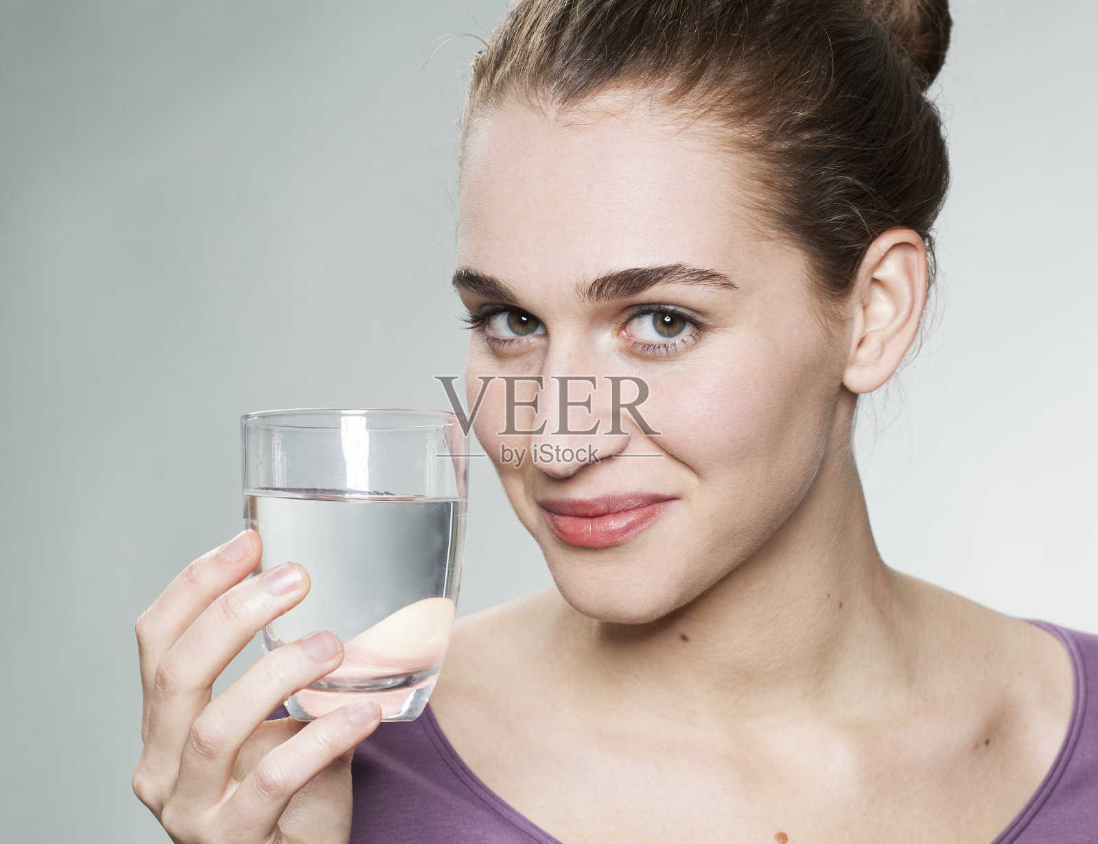 平静的20多岁女孩高兴地举起一杯水照片摄影图片