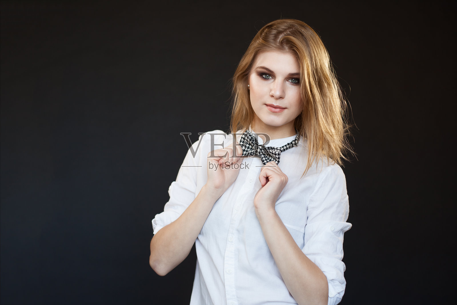 性感的女人在白色的衬衫与黑暗的背景照片摄影图片