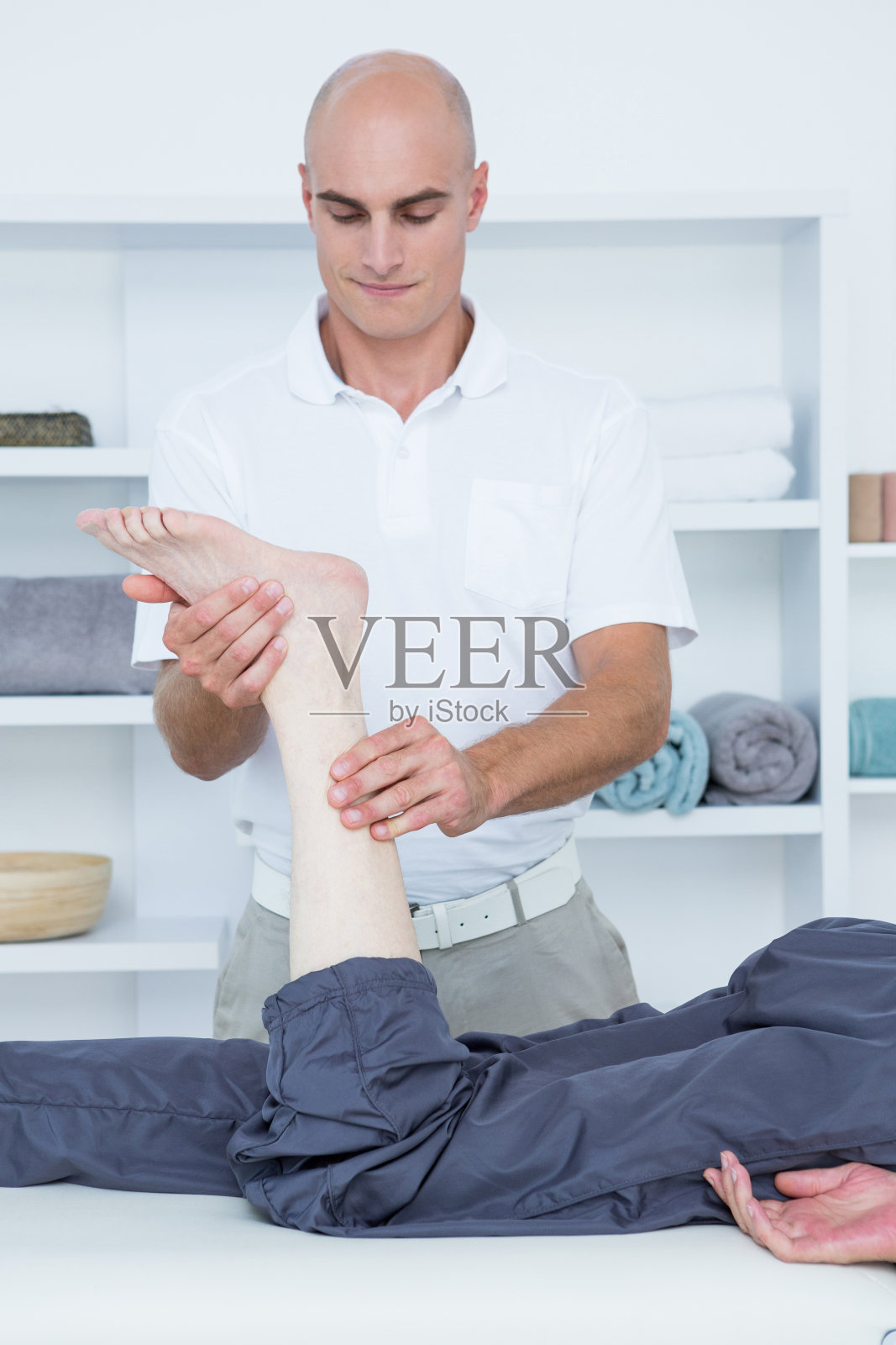 理疗师正在给病人做腿部按摩照片摄影图片