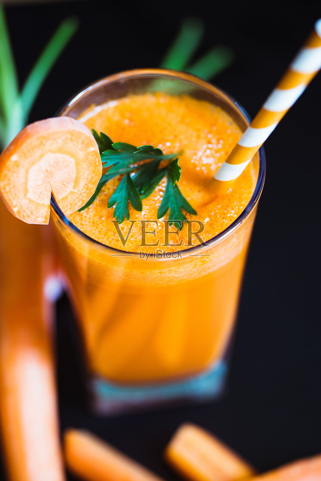 旁边的桌子上放着胡萝卜汁和蔬菜照片摄影图片