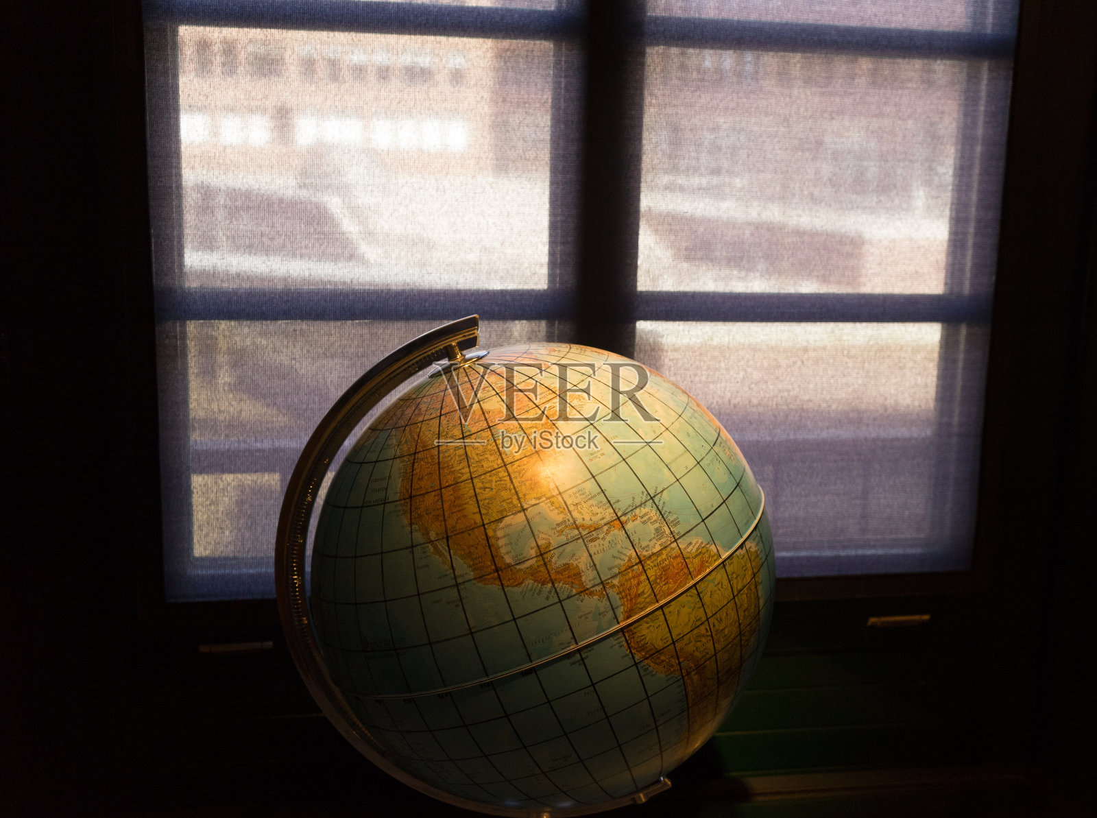靠窗的黑屋子里的地理地球仪照片摄影图片