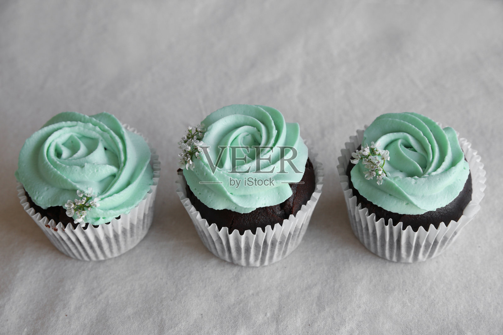 有绿松石玫瑰糖霜的自制巧克力小蛋糕照片摄影图片