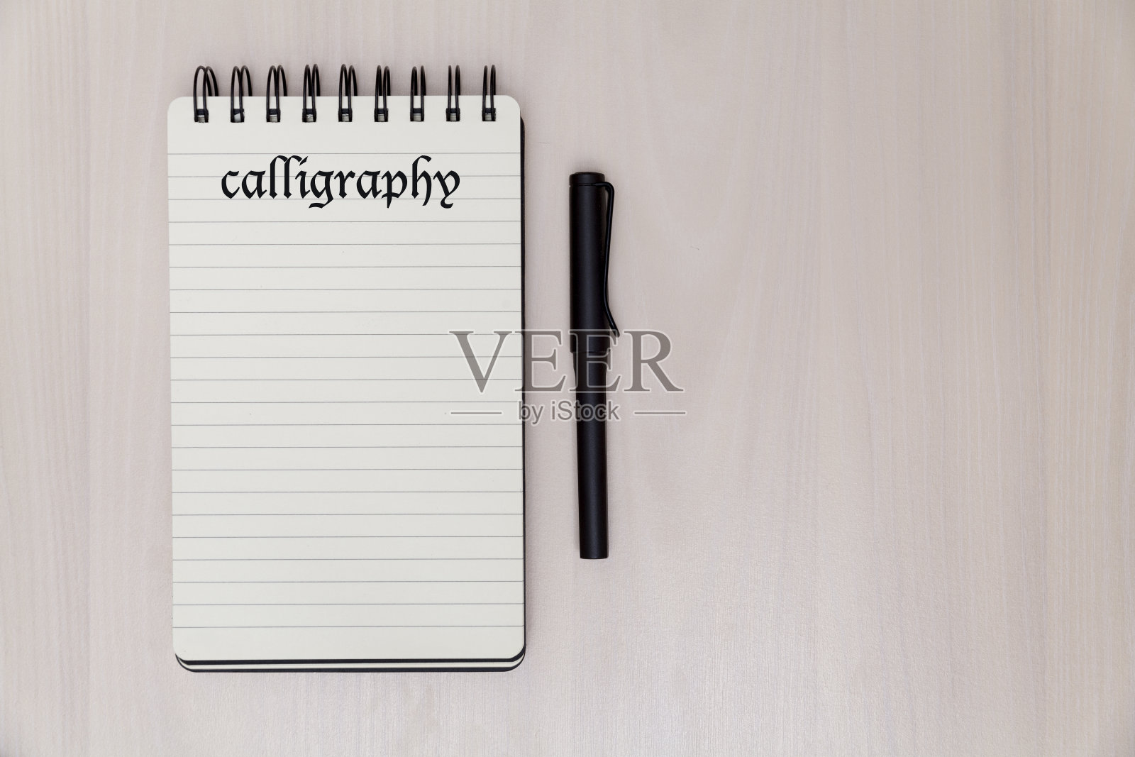 笔记本和笔上的书法文字照片摄影图片