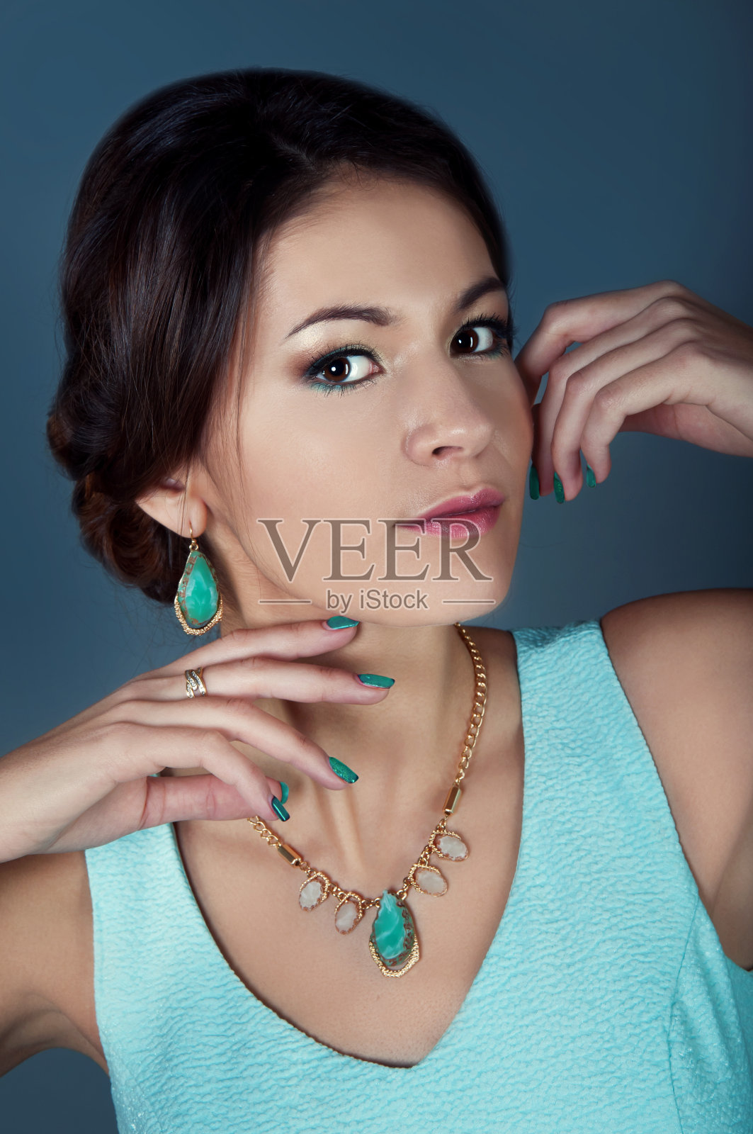 工作室肖像美丽的深褐色在蓝绿色的衣服照片摄影图片