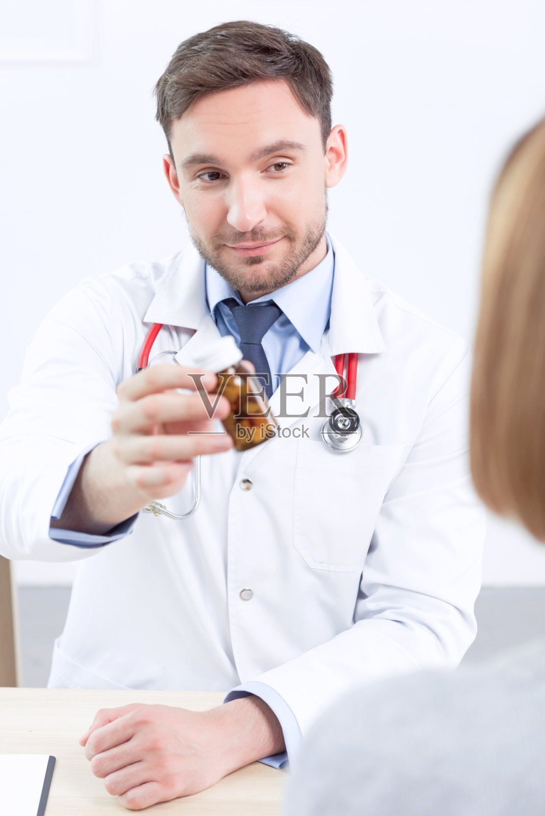 微笑的心脏病专家给病人吃药照片摄影图片